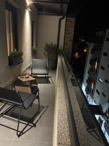 a room with two chairs and a table on a balcony at Apartman Idila in Ruma