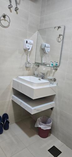 a bathroom with a white sink and a mirror at Luxury Furnished Apartment in Salalah Center in Salalah