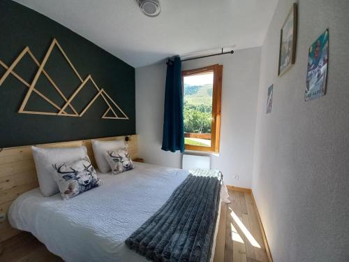 a bedroom with a bed with two pillows and a window at Apartment for 5-7 people in Saint-François-Longchamp