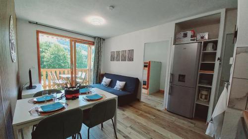 a kitchen and living room with a table and a couch at Apartment for 5-7 people in Saint-François-Longchamp