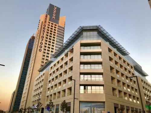 un grand bâtiment devant deux grands bâtiments dans l'établissement Amazing Studio in DAMAC, à Amman
