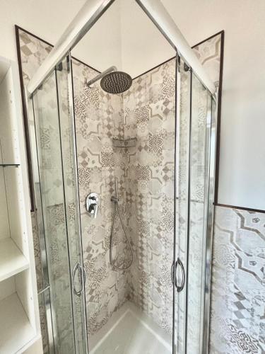 a shower with a glass door and a shower head at Il Mare in Tasca - Casa Vacanze - loc.Torre Lapillo (LE) - Salento in Torre Lapillo