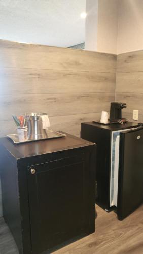 a kitchen with a sink and a black refrigerator at Valley Inn in Mission Hills