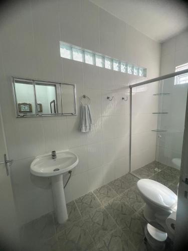 a white bathroom with a sink and a toilet at Casa do açude in Triunfo