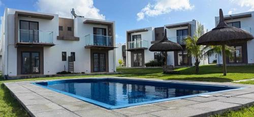 a house with a swimming pool in front of a building at Villa la Joie 2 bedrooms Apartment in Goodlands