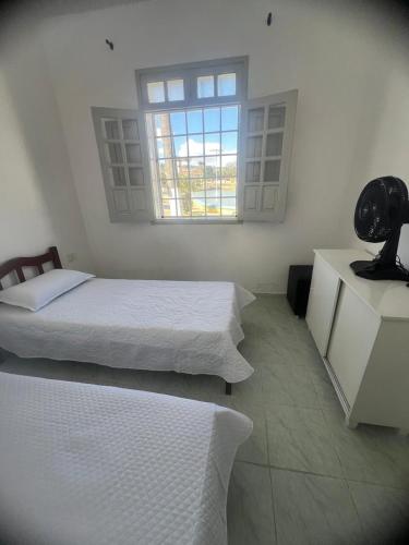 a bedroom with two beds and a window in it at Casa do açude in Triunfo