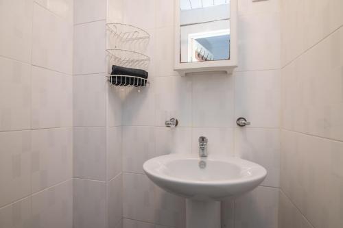 a white bathroom with a sink and a mirror at 5 BD - Large House Oadby in Oadby