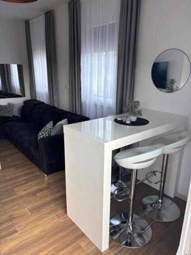 a kitchen with a white island in a living room at Apartman Idila in Ruma