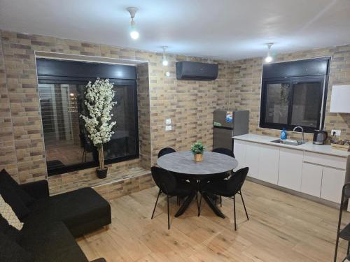 a kitchen and dining room with a table and chairs at הזית והרימון in Keshet