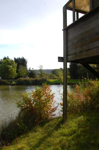 a bench sitting next to a body of water at Castleton Static lodge on Wold View Fisheries Leisure Park in Usselby