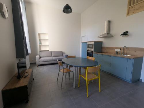 a kitchen with a table and chairs in a room at La Bonne Ecole in Les Landes-Génusson