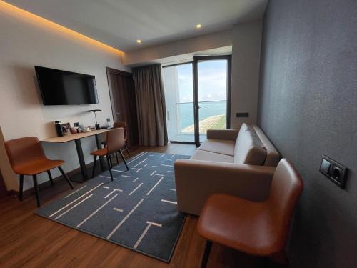 a living room with a couch and a table with chairs at Marriot by Batumi in Batumi
