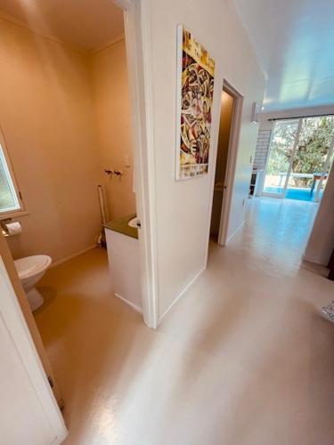 ein leeres Bad mit WC und Flur in der Unterkunft Mango Grove Cottage in Rarotonga