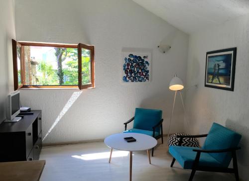 salon z 2 krzesłami, stołem i oknem w obiekcie Apartments Sunny Split w Splicie