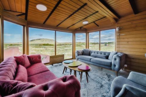 ein Wohnzimmer mit einer Couch und Stühlen und einem Tisch in der Unterkunft Large luxury Cabin On The Golden Circle Next To Kerið The Crater. in Selfoss