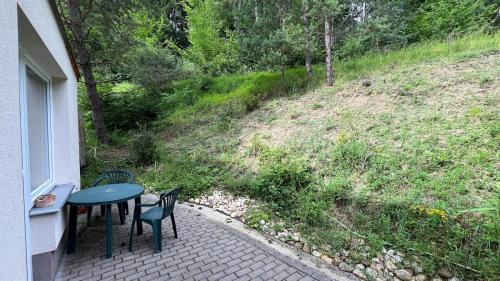 eine Terrasse mit einem Tisch, Stühlen und einem Hügel in der Unterkunft Všemina apartmán s terasou in Všemina