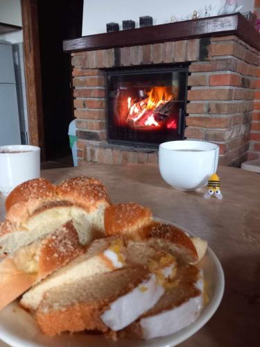 a plate of bread on a table with a fireplace at Dom na końcu wsi in Burzec