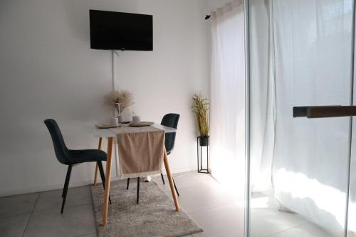 Un comedor con mesa y sillas y un televisor. en RheinMosel Wellness 11, en Coblenza