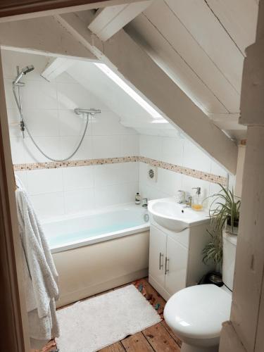 a bathroom with a tub and a toilet and a sink at The Little Welsh Cottage in Brynmenin