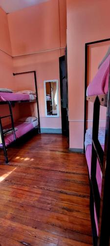 a room with bunk beds and a wooden floor at Windmill Hostel in Mendoza
