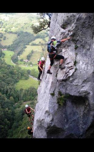 a group of people climbing on a rock wall at El Paraíso de Aitana in Ramales de la Victoria