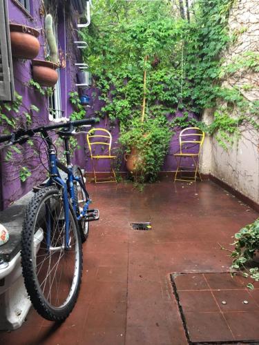 a bike parked next to a purple building with chairs at Villa Selva Mid-century Design House Vicente López in Vicente López