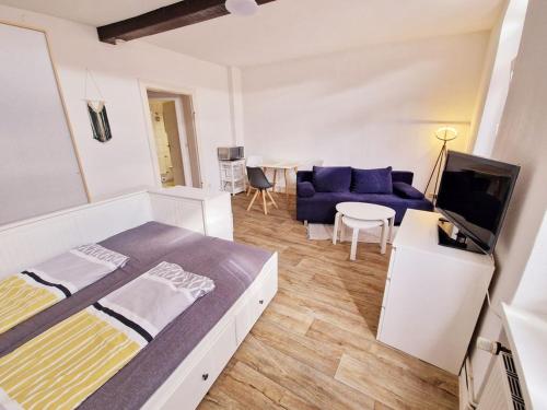 a bedroom with a bed and a blue couch at Urlaub im Herzen Wismars 2OG Süd in Wismar
