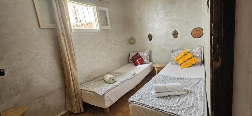 a room with two beds and a mirror at Idriss Seaview Guesthouse in Taghazout