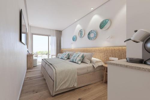 a bedroom with a bed with blue plates on the wall at Hotel Moré in Alcudia