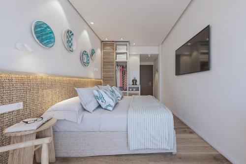 a bedroom with a bed with blue pillows at Hotel Moré in Alcudia