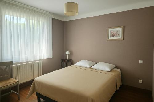 a bedroom with a large bed and a window at Maison confortable avec 3 chambres et jardin clos, idéale familles et curistes à Salies-de-Béarn in Salies-de-Béarn