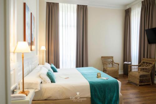 a hotel room with a bed with a teddy bear on it at Hotel Villa Rosario, Palacete in Ribadesella