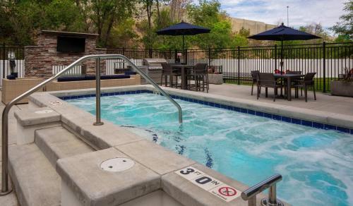 een zwembad met een trap naar een patio bij Bright 2BR SLC Apt Hot Tub Parking in Salt Lake City