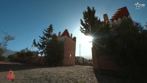 un edificio con el sol brillando detrás de él en Camping Granit Rose, en Tafraoute