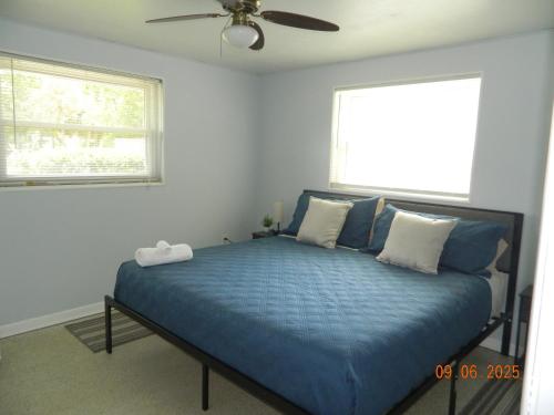 a bedroom with a blue bed with a ceiling fan at Chazzdoorway 2rooms 1 bathroom Duplex in Homosassa