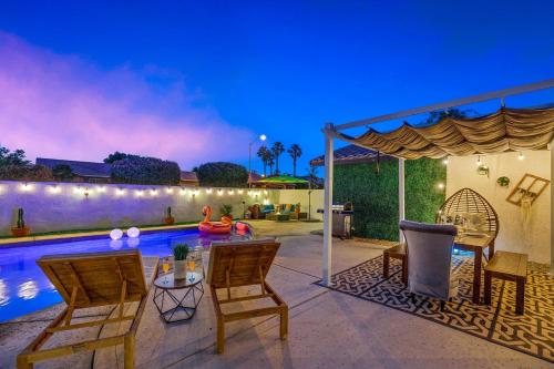 a patio with chairs and a swimming pool at night at Desert Fun 5BR Retreat with Pool in Bermuda Dunes