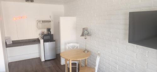 a small kitchen with a small table and a small refrigerator at Brad's Desert Inn in Holbrook