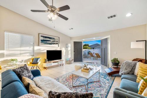 a living room with a blue couch and a tv at 4BR Desert Escape PoolGame Room in Bermuda Dunes