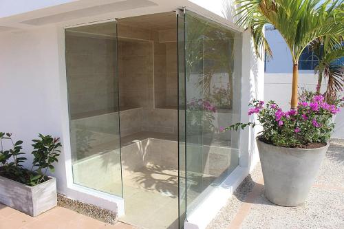 una ducha con un recinto de cristal junto a algunas plantas en Cartagena Beach Front, en Cartagena de Indias