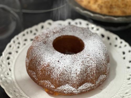 a sugar covered donut sitting on a white plate at Almà in Torre delle Stelle