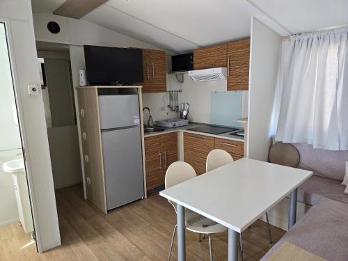 a small kitchen with a white table and a white table at Auto-kamp Dvije suze 2 in Brištane