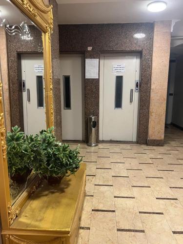 a mirror in a hallway with three elevators at New Apartment AlMohandessin near Shehab street in Cairo