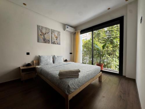 a bedroom with a bed and a large window at Cozy green studio - Self check in, Prime location, Free parking in Casablanca