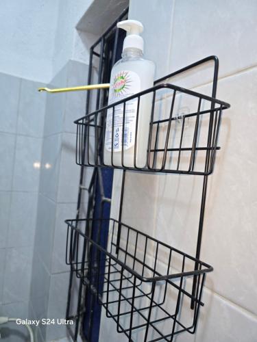 Una botella de jabón en una canasta en la pared del baño. en SK CBD Suites airb Wundanyi Taita Taveta County, en Wundanyi