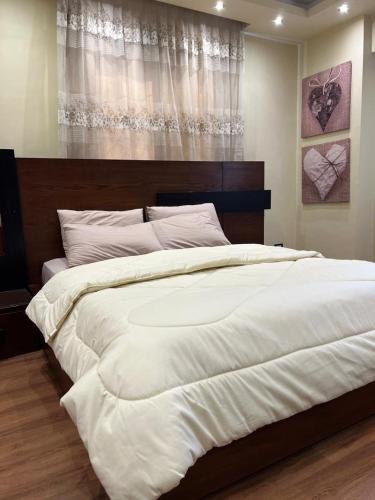 a large white bed in a bedroom with a window at New Apartment AlMohandessin near Shehab street in Cairo