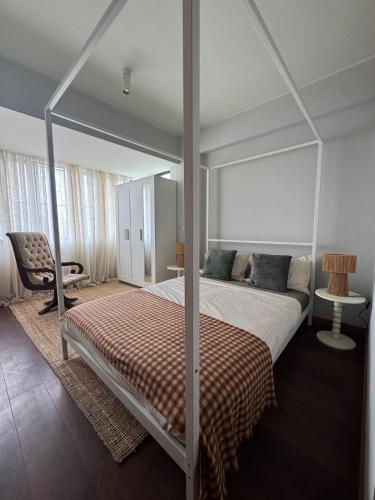 een slaapkamer met een hemelbed en een stoel bij Casa da Música Apartment in Porto