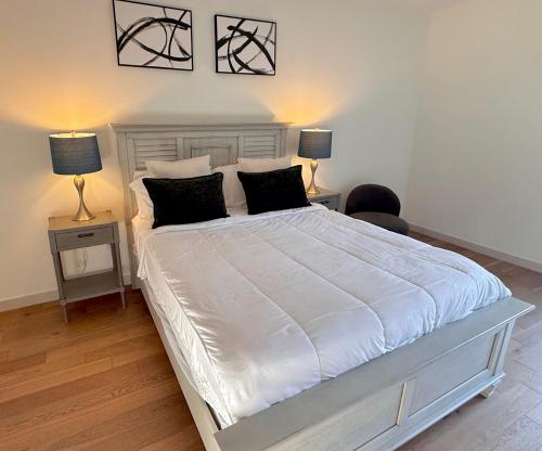 Un dormitorio con una gran cama blanca con dos lámparas. en Hollywood Walk of Fame I Pool View I Fitness Center I Free Parking!, en Los Ángeles