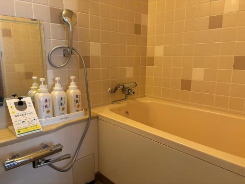 a bathroom with a bath tub and a shower at KOUBOUNOYU IKONASOU in Shizuoka