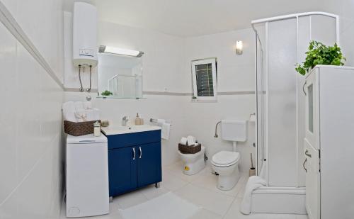 a bathroom with a toilet and a sink and a shower at Apartman Roza in Rogoznica