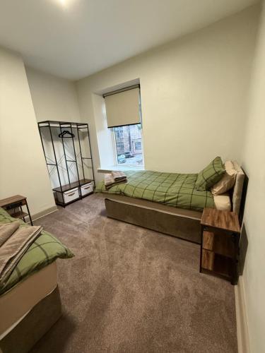a room with two beds and a window at 128-130 Crookes in Walkley